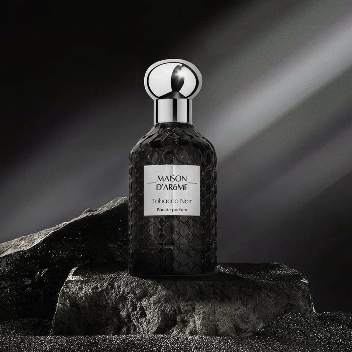 Tobacco Noir on dark stone under a shaft of light